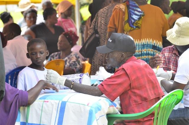 A health worker performs a finger-prick blood glucose test at a community screening outreach.