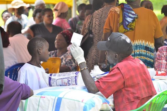Close view of a health worker taking a blood sample from a community member’s finger.