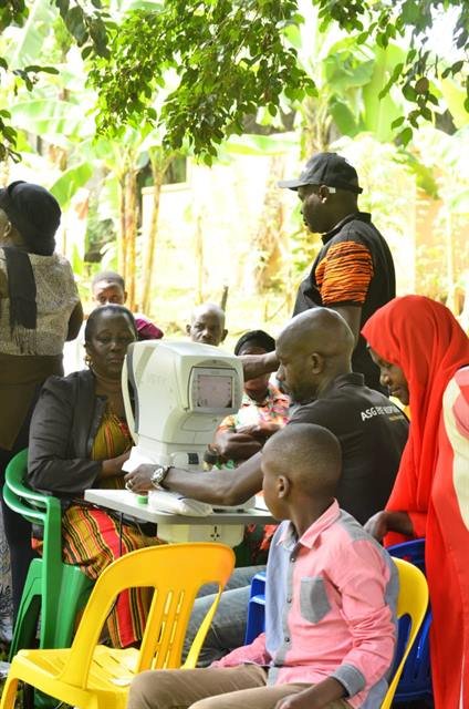 Community members wait their turn beside screening equipment at an outreach event.