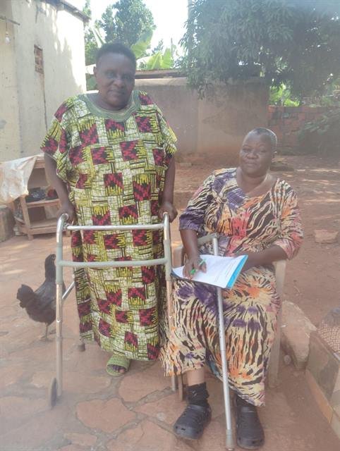 A woman stands supported by a walking frame provided through RDAF's rehabilitation support.