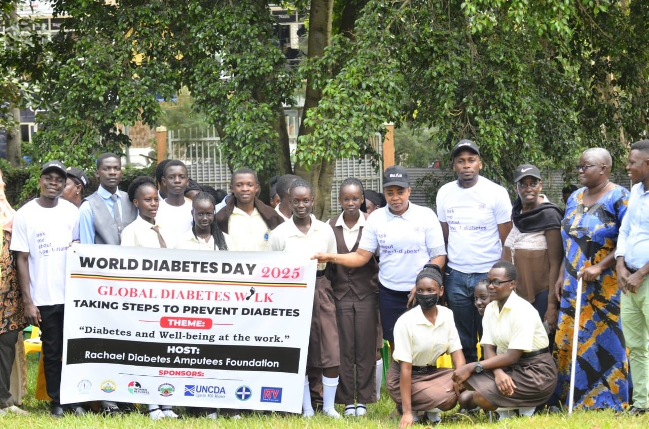 Schoolchildren and community members gathered behind an RDAF World Diabetes Day banner.